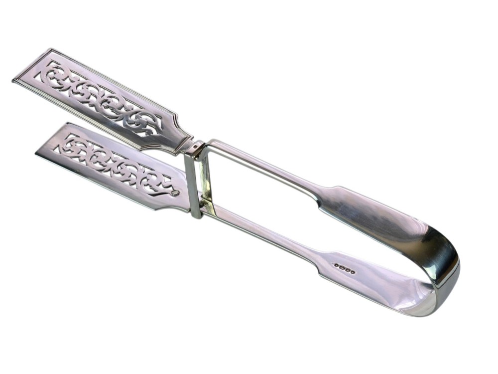 Victorian sterling silver asparagus tongs featuring wide, pierced scrollwork blades and clear assay hallmarks along the upper arm. View VIII