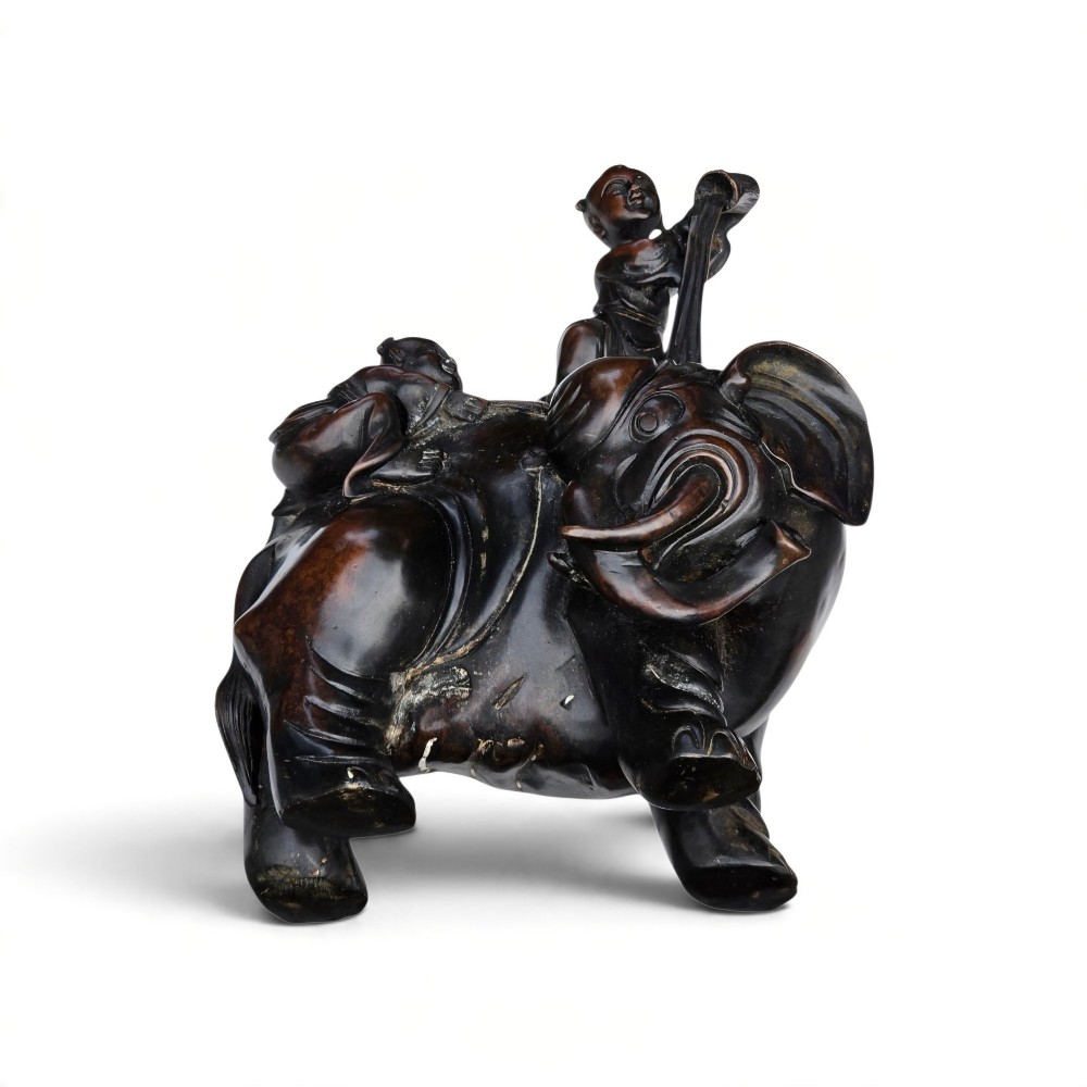 A dark patinated bronze Chinese sculpture depicting two young boys washing a caparisoned elephant. View VI