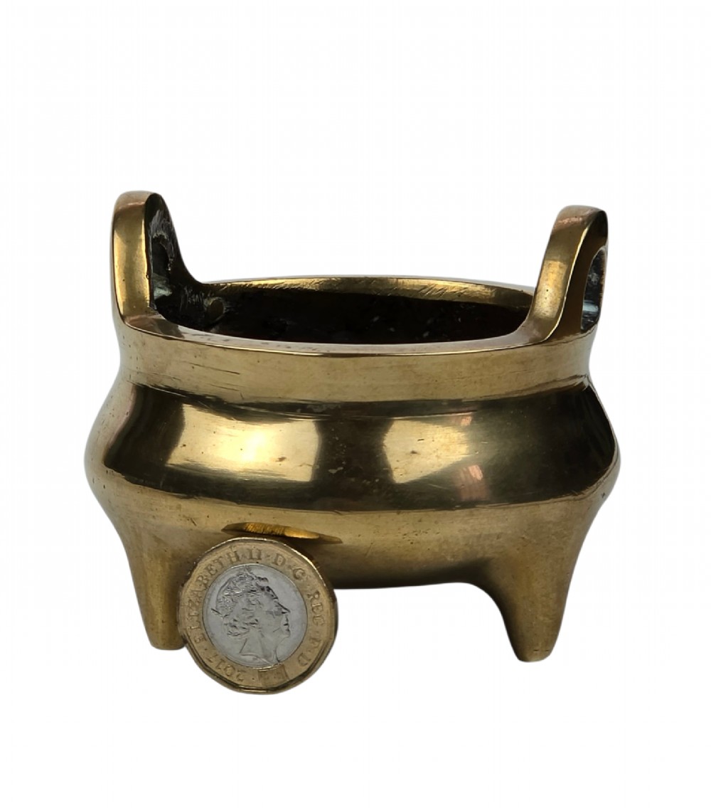 A miniature cast bronze tripod censer featuring loop handles, conical legs, and natural surface patination. View VIII