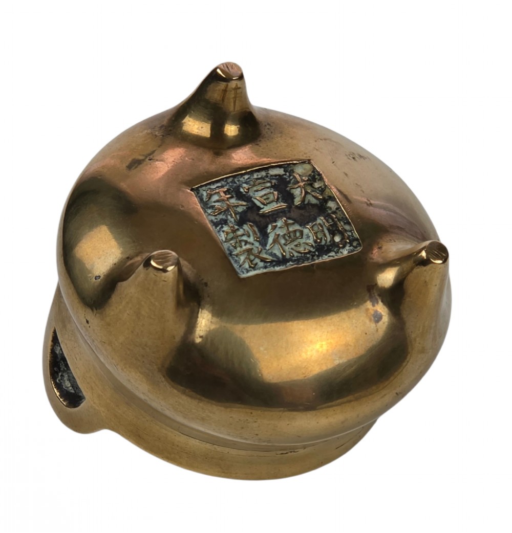 A miniature cast bronze tripod censer featuring loop handles, conical legs, and natural surface patination. View IX