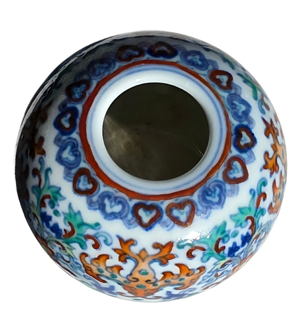 A rounded Chinese porcelain water pot decorated in doucai enamels with lotus flowers, bats, and scrolling foliage. View X