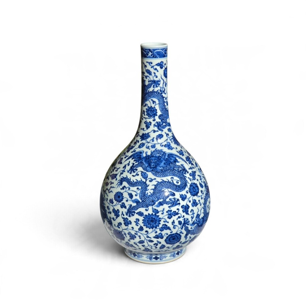 A pear-shaped Chinese porcelain bottle vase decorated with detailed underglaze cobalt blue five-clawed dragons amidst floral scrolls. View II
