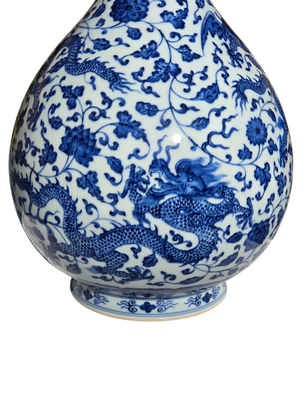 A pear-shaped Chinese porcelain bottle vase decorated with detailed underglaze cobalt blue five-clawed dragons amidst floral scrolls. View X