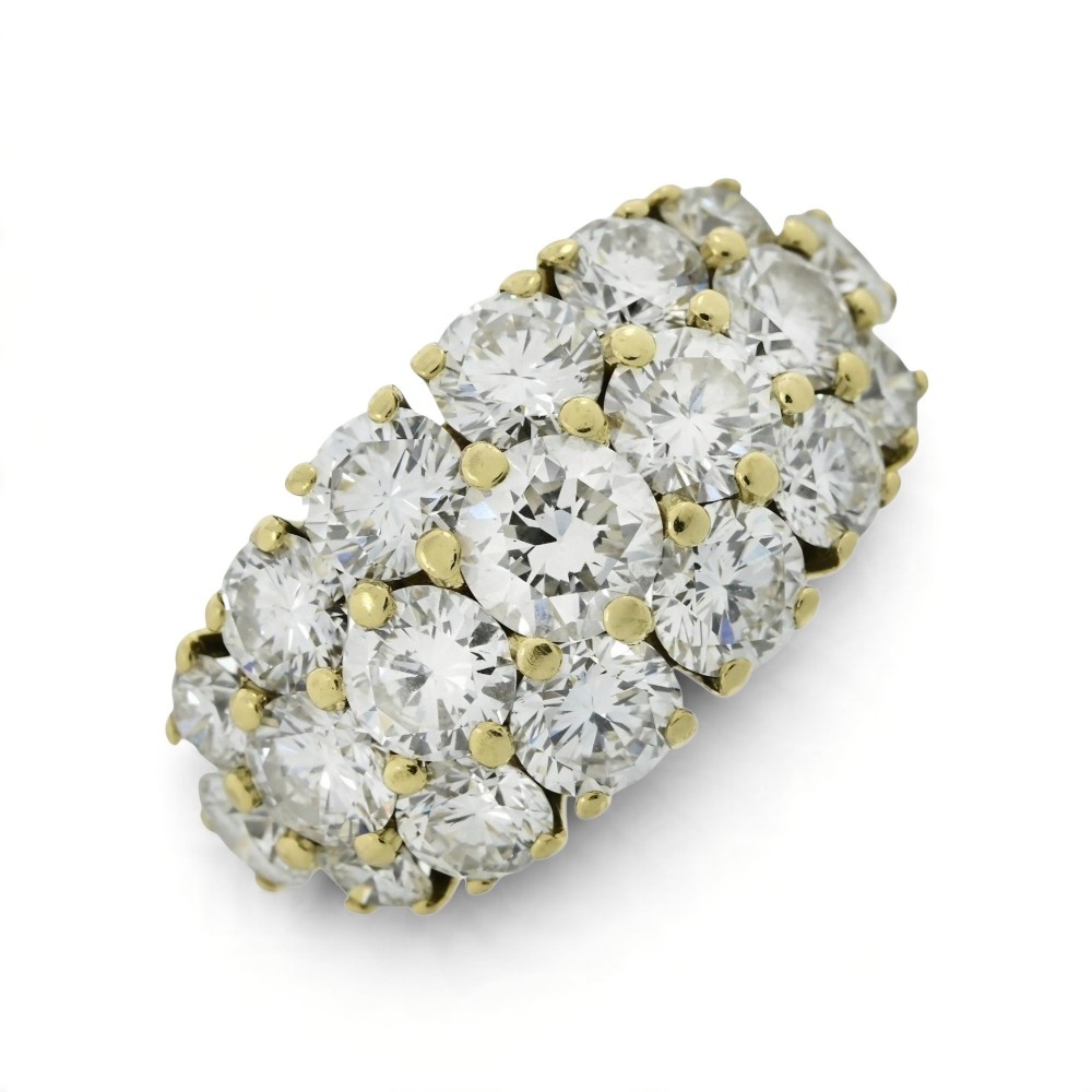 An 18ct yellow gold dome cluster ring closely set with multiple round brilliant cut diamonds in claw settings.