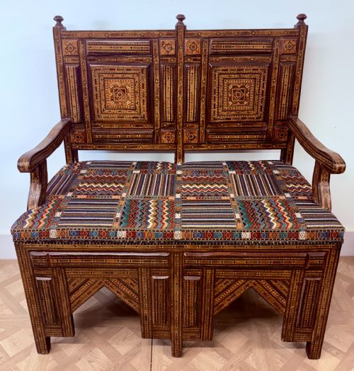 fig 1. A 19th-century double-back Syrian hardwood bench featuring intricate geometric bone and timber parquetry inlay with a patterned upholstered seat.