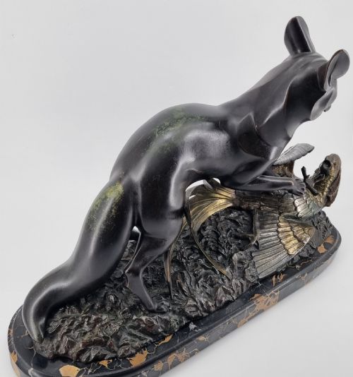 fig 1. A dark patinated bronze sculpture depicting a fox capturing a pheasant mounted on a black veined marble base.