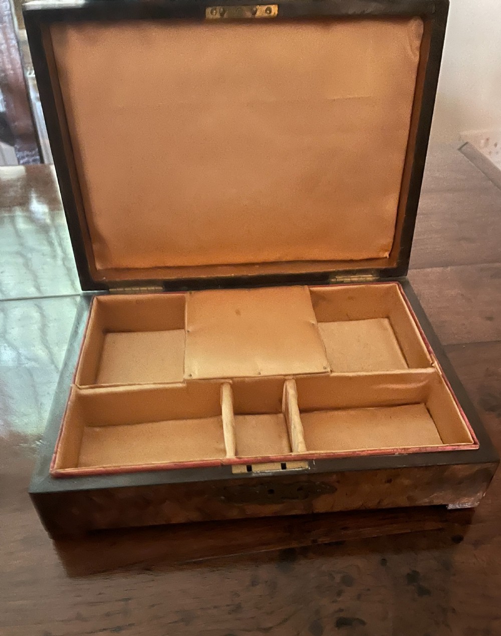 A rectangular Victorian burr walnut games box featuring decorative brass corner mounts shaped like playing cards and a fan-shaped brass playing card motif on the lid. View III