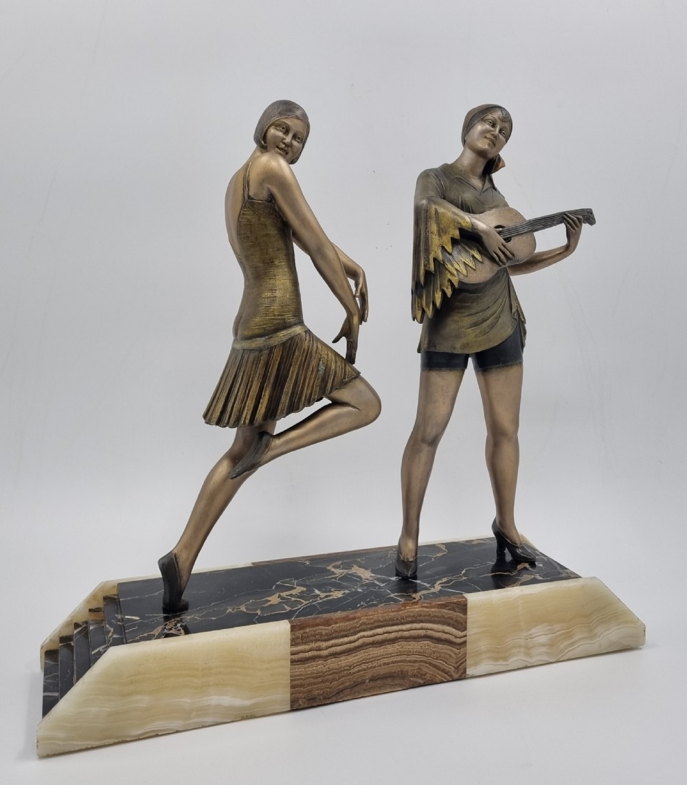 An Art Deco bronze sculpture featuring a dancing woman and a musician playing a stringed instrument set upon a layered onyx and marble plinth base. View III
