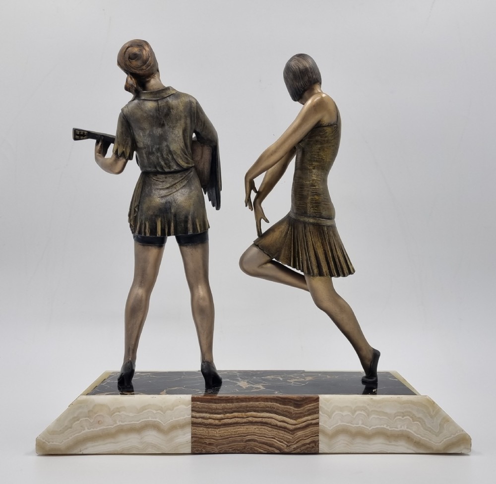 An Art Deco bronze sculpture featuring a dancing woman and a musician playing a stringed instrument set upon a layered onyx and marble plinth base. View VI