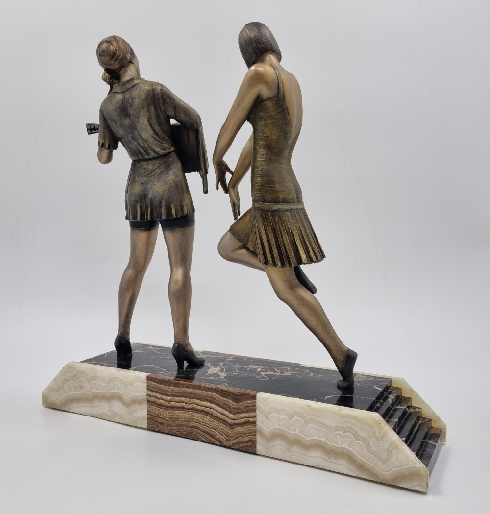 An Art Deco bronze sculpture featuring a dancing woman and a musician playing a stringed instrument set upon a layered onyx and marble plinth base. View VII