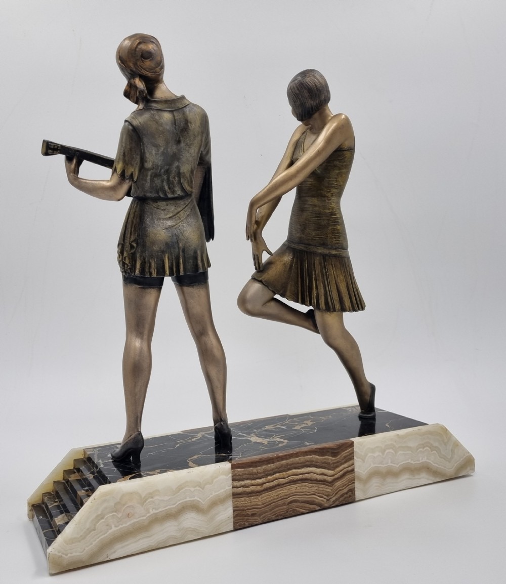 An Art Deco bronze sculpture featuring a dancing woman and a musician playing a stringed instrument set upon a layered onyx and marble plinth base. View VIII