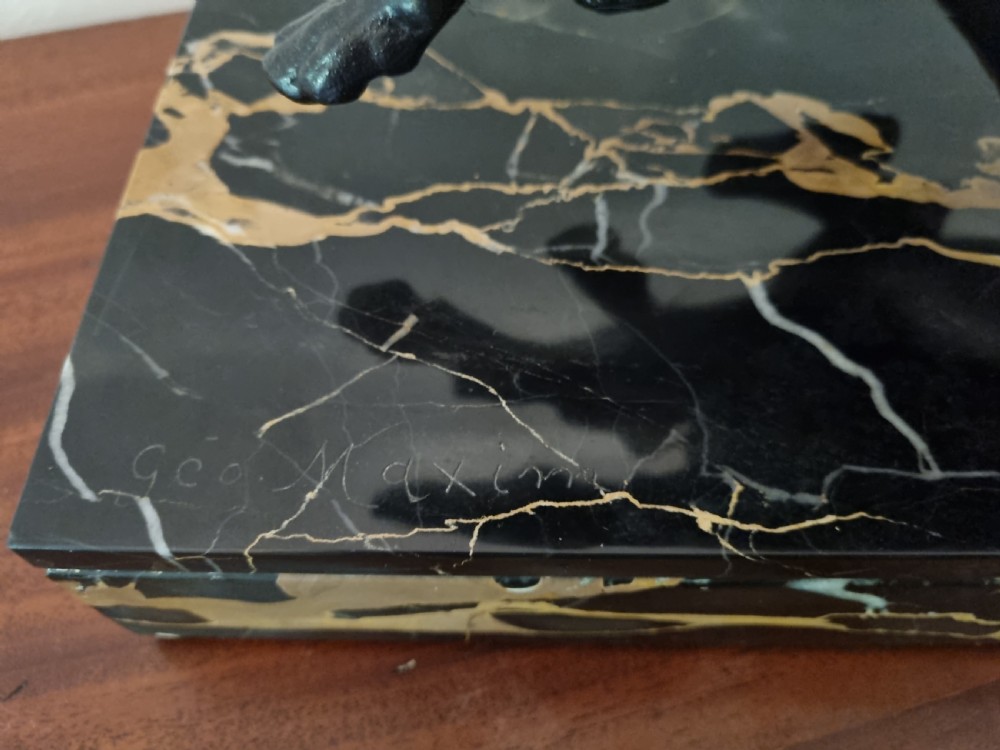 An Art Deco sculpture depicting a silvered female figure running alongside two dark greyhounds, mounted on a black marble base. View XII