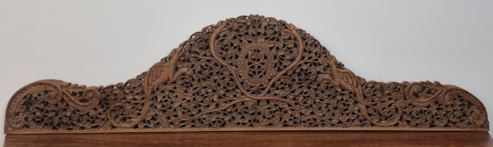 A 19th-century Anglo-Indian intricately carved teak wood cabinet featuring openwork floral lattice panels, figure pilasters, arched cresting, and carved animal feet. View VIII