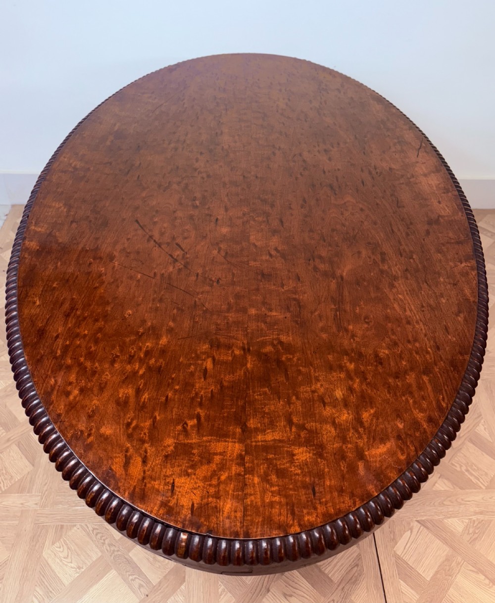 A circular Regency burr walnut centre table featuring a carved spiral pedestal and a four-legged base with carved animal feet. View III