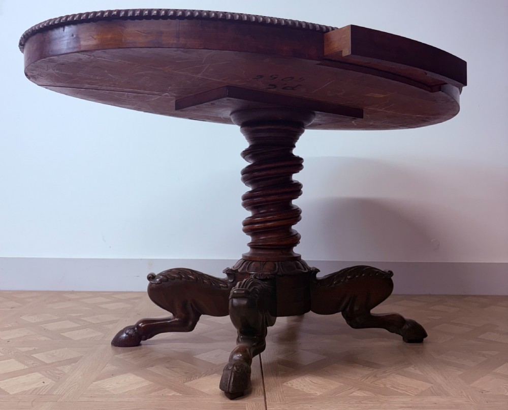 A circular Regency burr walnut centre table featuring a carved spiral pedestal and a four-legged base with carved animal feet. View VII