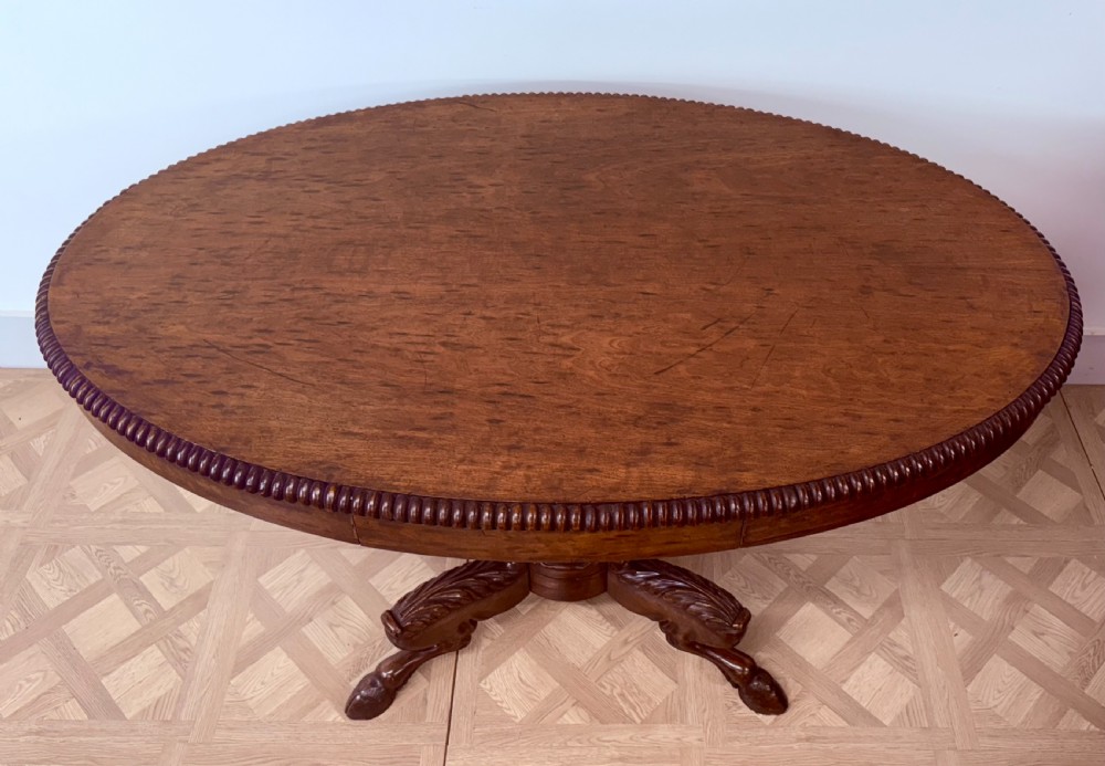 A circular Regency burr walnut centre table featuring a carved spiral pedestal and a four-legged base with carved animal feet. View VIII