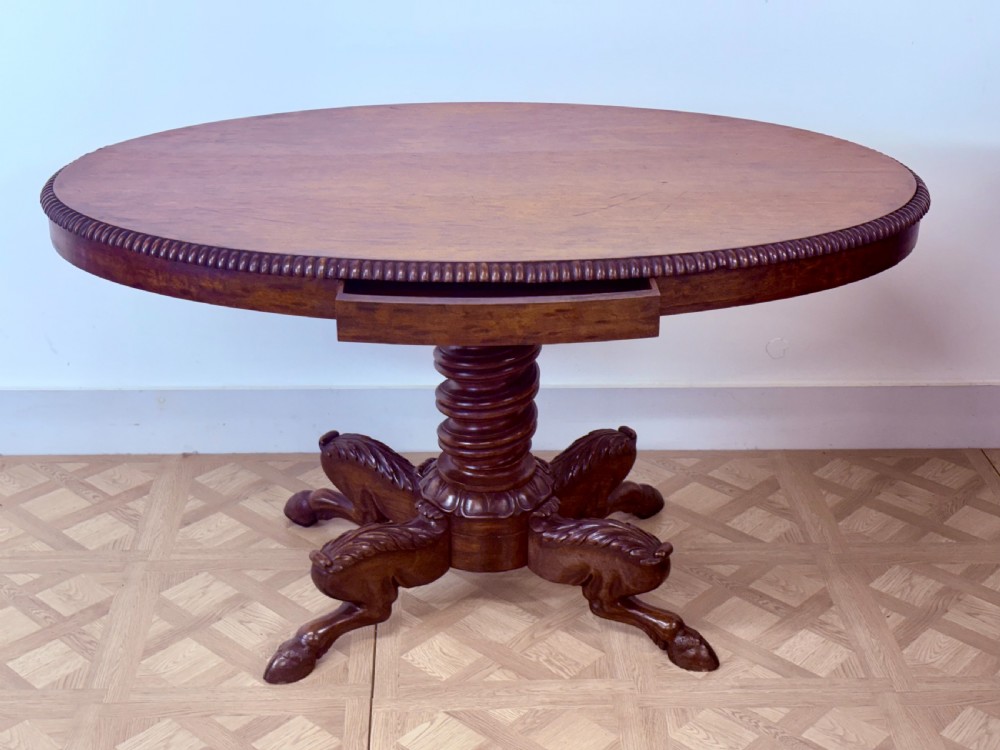A circular Regency burr walnut centre table featuring a carved spiral pedestal and a four-legged base with carved animal feet. View IX