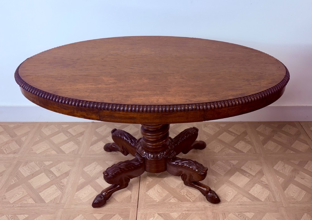 A circular Regency burr walnut centre table featuring a carved spiral pedestal and a four-legged base with carved animal feet. View X