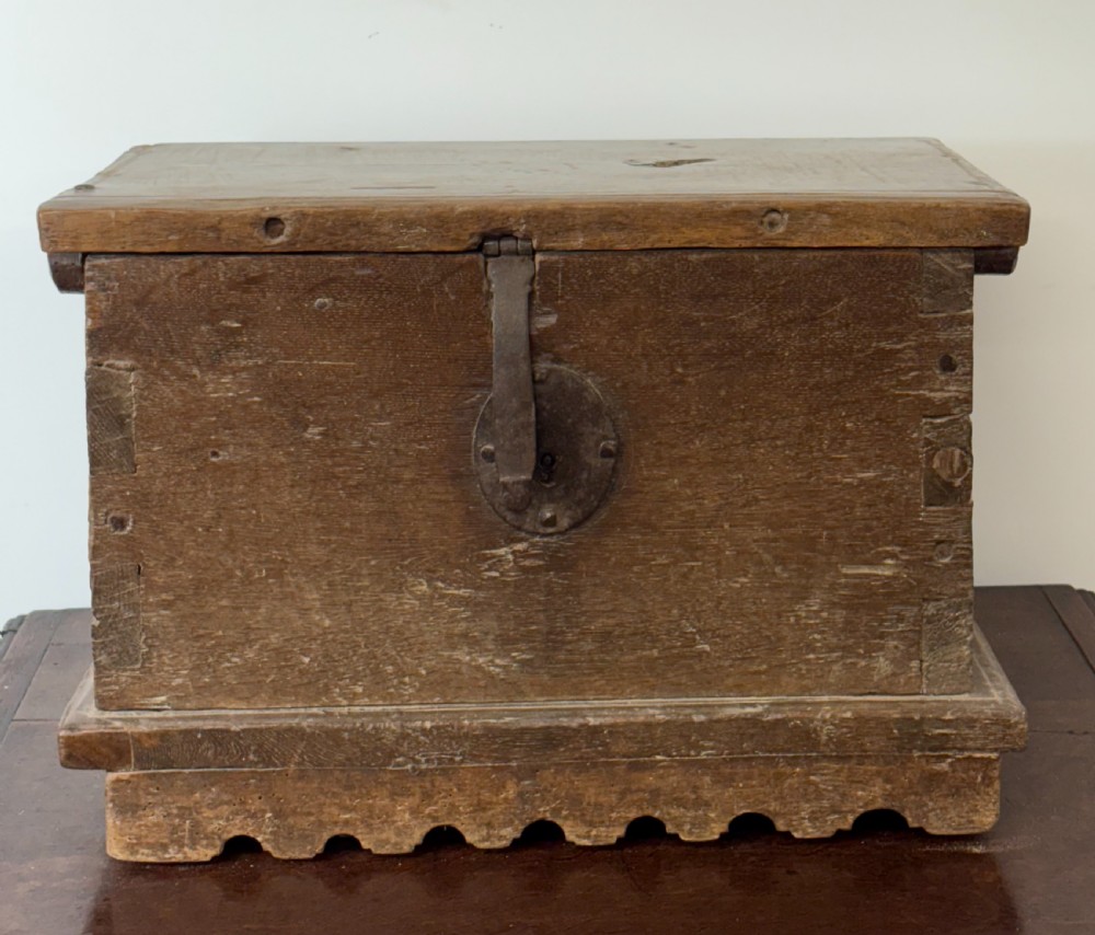 A late sixteenth to early seventeenth-century Flemish oak coffer featuring hand-forged iron clasp hardware, wooden pegs, and a scalloped base plinth. View III