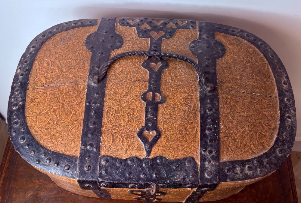An oval 18th-century Swedish folk art trunk featuring an ochre painted textured finish, dark wrought iron bands, studs, and a heart-shaped latch. View V