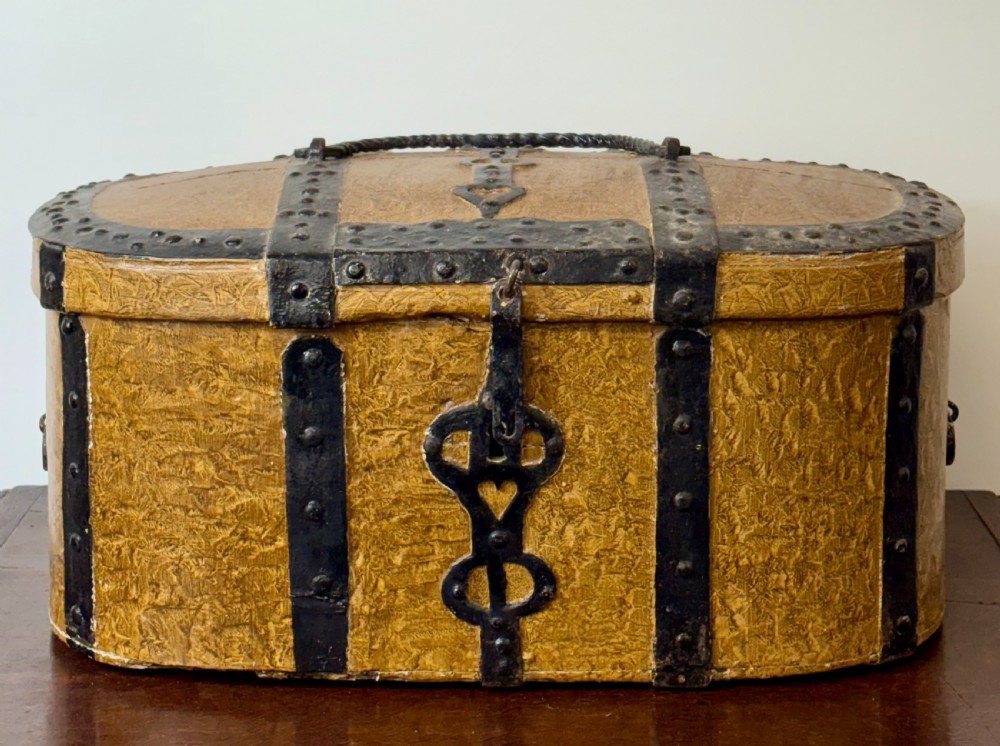 An oval 18th-century Swedish folk art trunk featuring an ochre painted textured finish, dark wrought iron bands, studs, and a heart-shaped latch. View VI