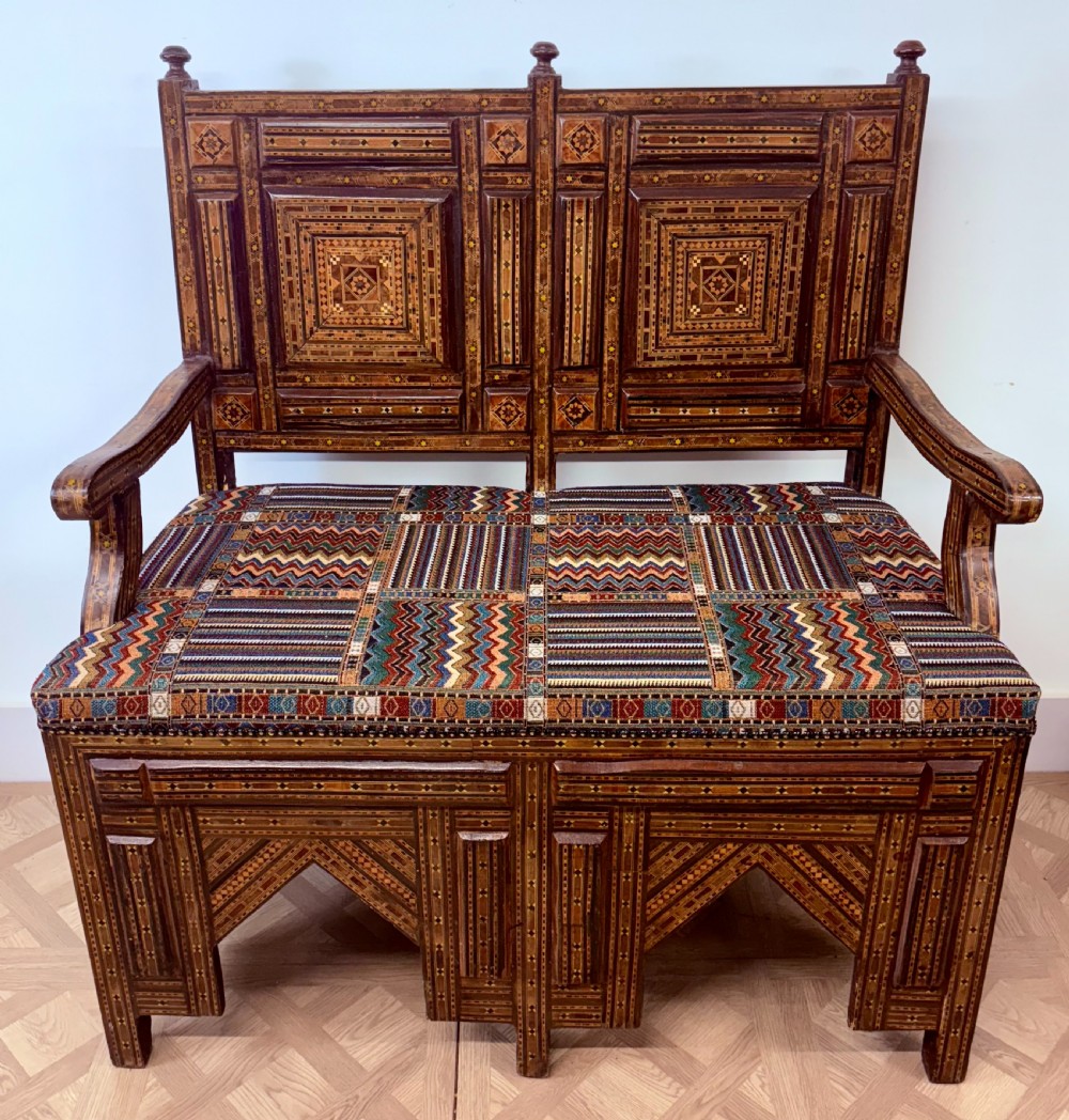 A 19th-century double-back Syrian hardwood bench featuring intricate geometric bone and timber parquetry inlay with a patterned upholstered seat. View II