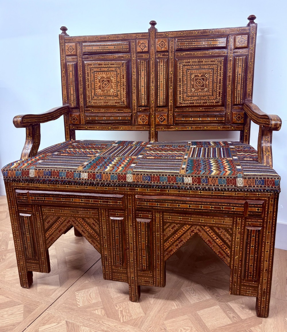 A 19th-century double-back Syrian hardwood bench featuring intricate geometric bone and timber parquetry inlay with a patterned upholstered seat. View VII