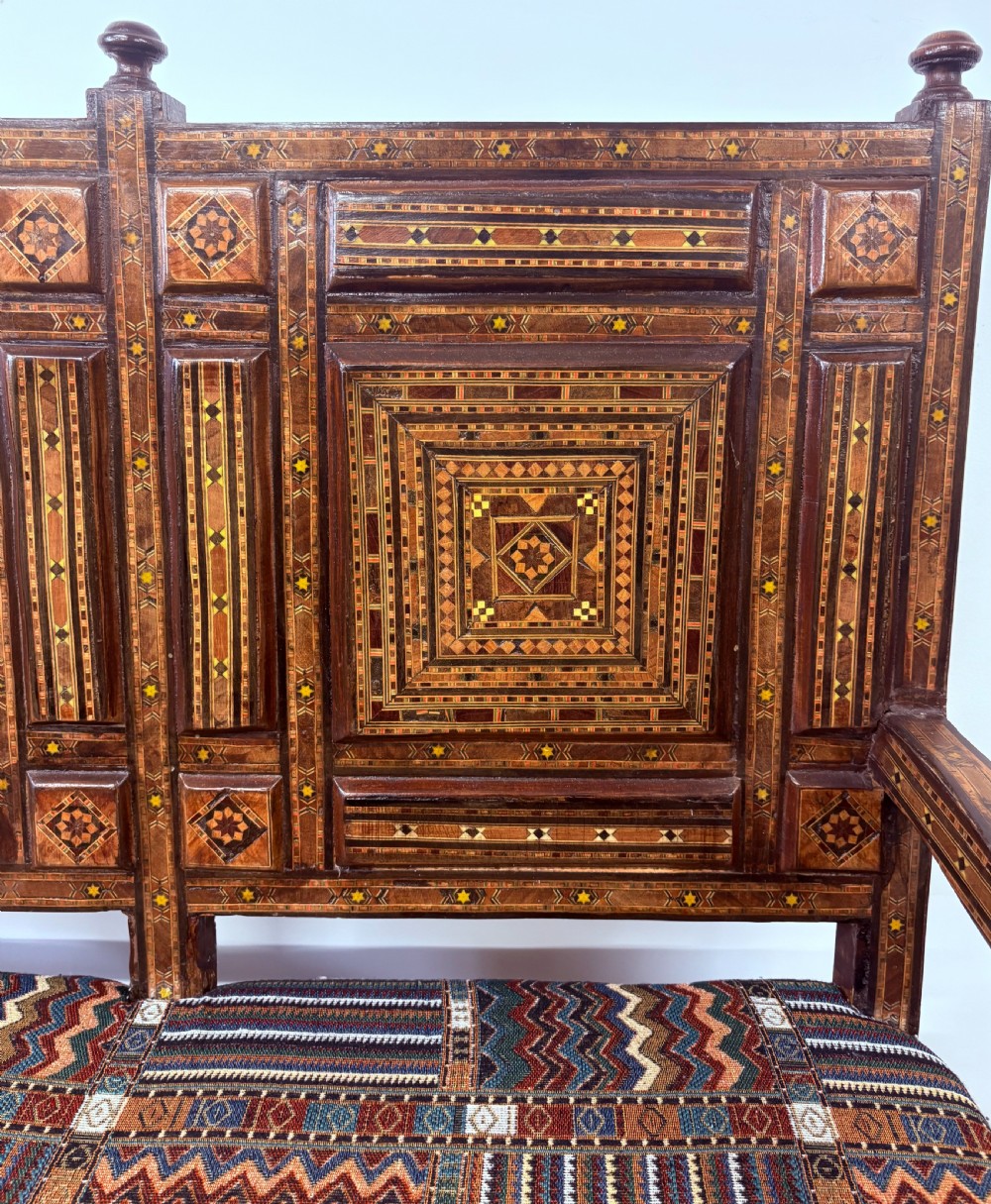 A 19th-century double-back Syrian hardwood bench featuring intricate geometric bone and timber parquetry inlay with a patterned upholstered seat. View XV
