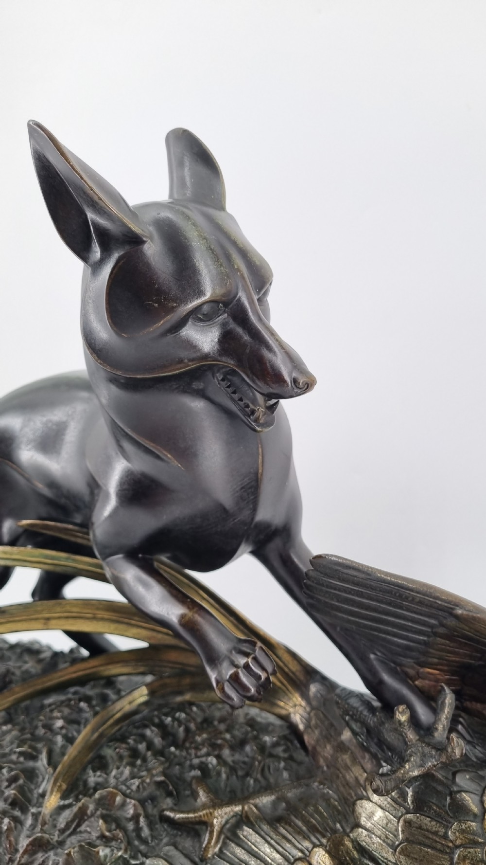 A dark patinated bronze sculpture depicting a fox capturing a pheasant mounted on a black veined marble base. View VI