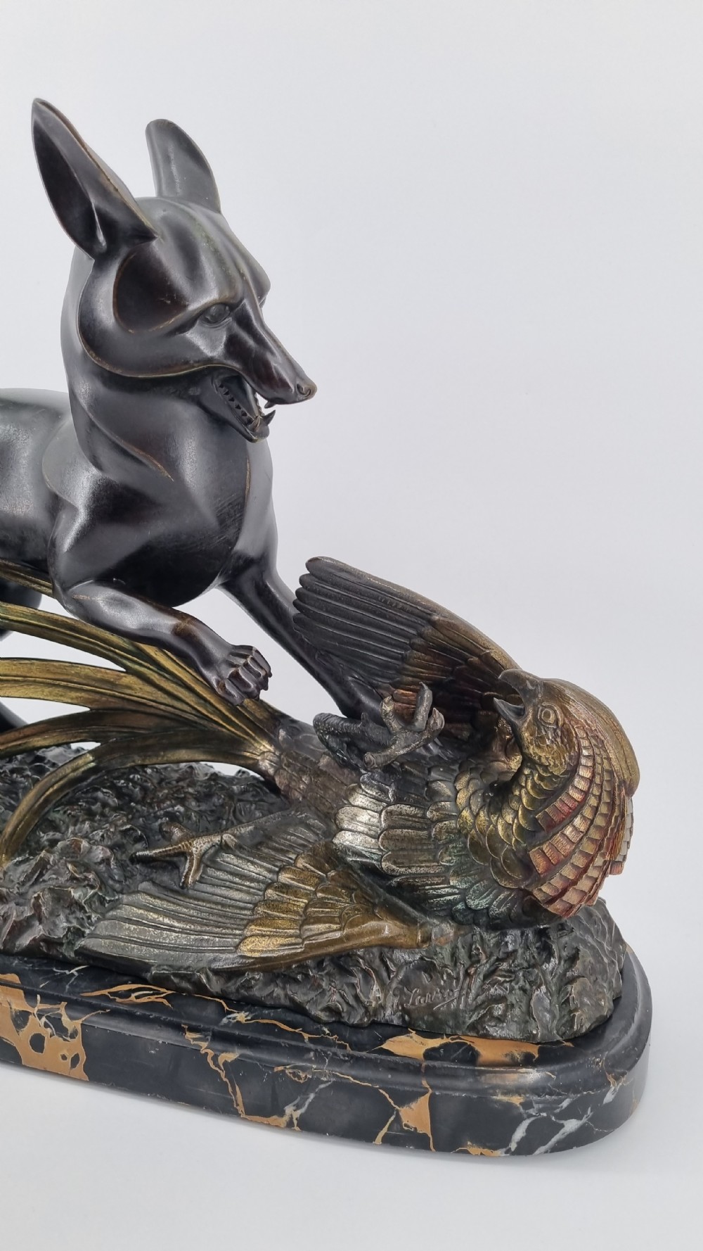 A dark patinated bronze sculpture depicting a fox capturing a pheasant mounted on a black veined marble base. View VIII