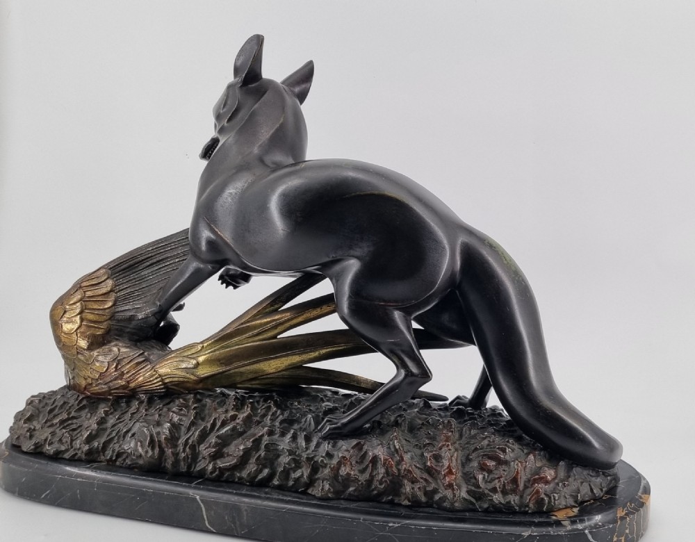 A dark patinated bronze sculpture depicting a fox capturing a pheasant mounted on a black veined marble base. View XV