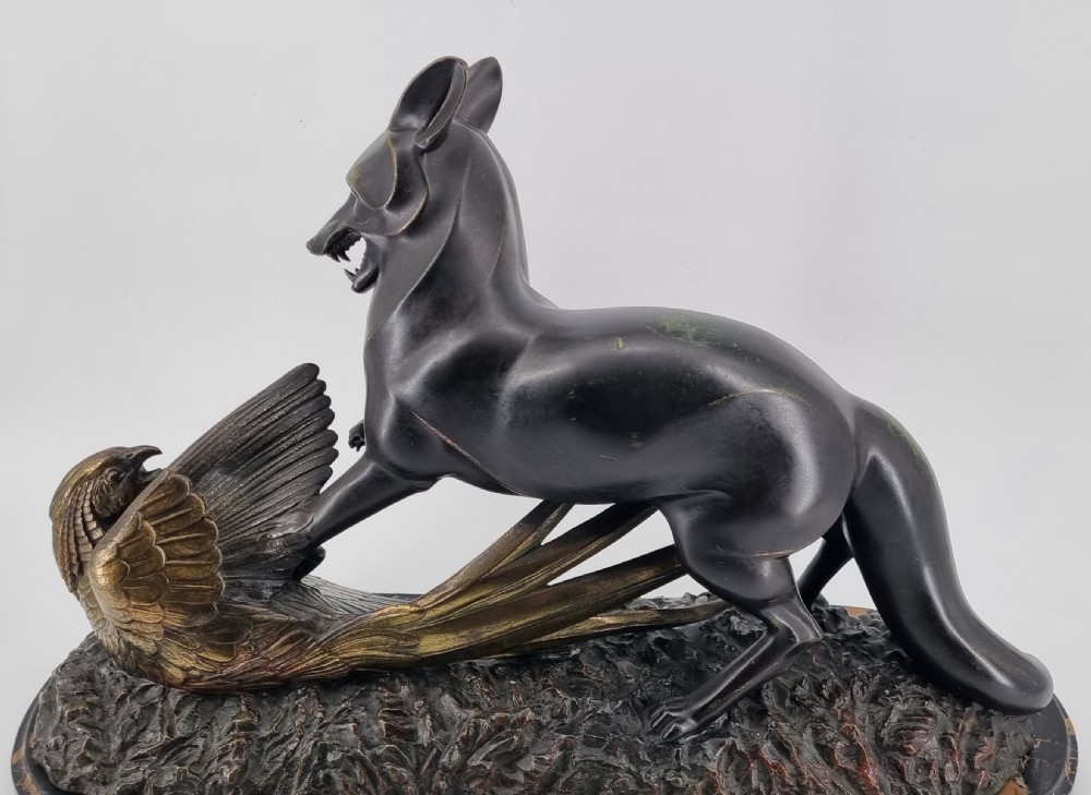 A dark patinated bronze sculpture depicting a fox capturing a pheasant mounted on a black veined marble base. View XVI