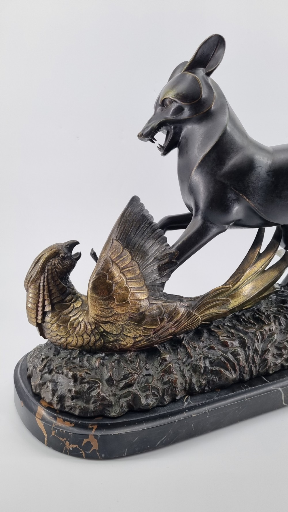A dark patinated bronze sculpture depicting a fox capturing a pheasant mounted on a black veined marble base. View XVIII