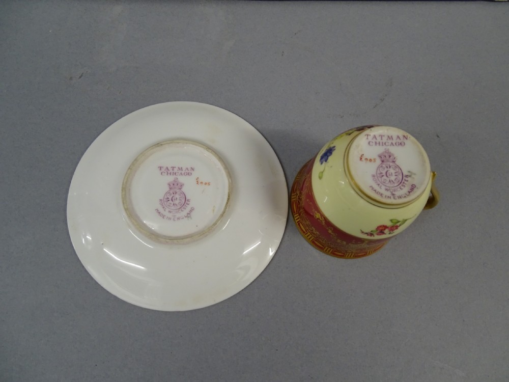 A Royal Worcester demitasse cup and matching saucer featuring crimson ground decoration, gilded floral swags, and a hand-painted floral centre. View III