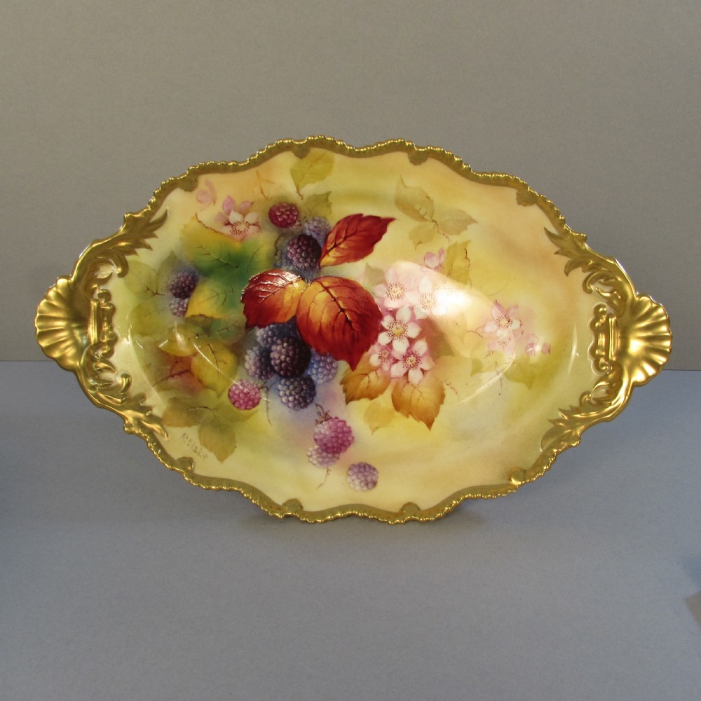 An oval hand-painted porcelain comport featuring a motif of blackberries and autumn leaves with gilded handles and a pedestal base. View II