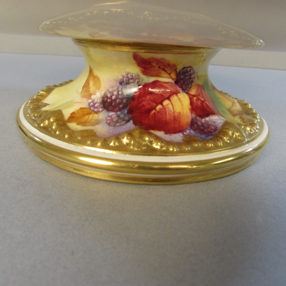 An oval hand-painted porcelain comport featuring a motif of blackberries and autumn leaves with gilded handles and a pedestal base. View III