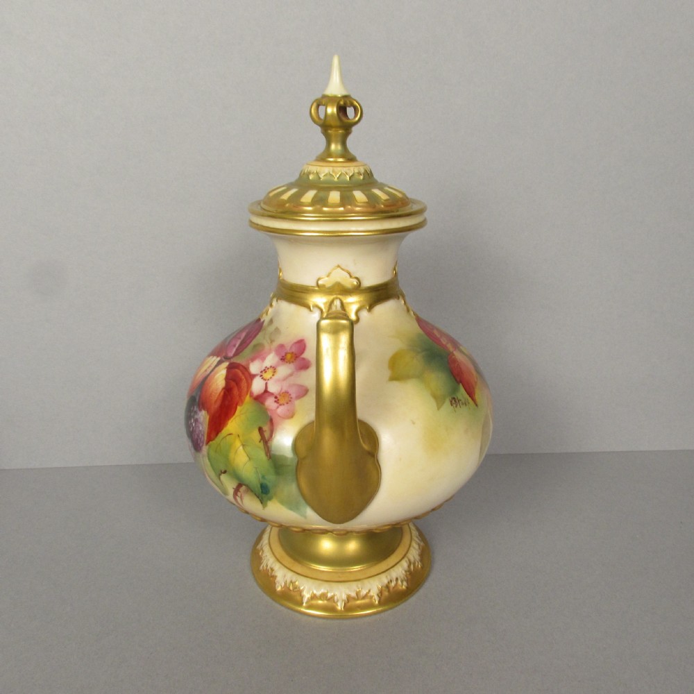 A twin-handled porcelain urn with a finial lid, featuring hand-painted autumn foliage and fruit decoration with rich gilding on the handles, neck, and base. View II