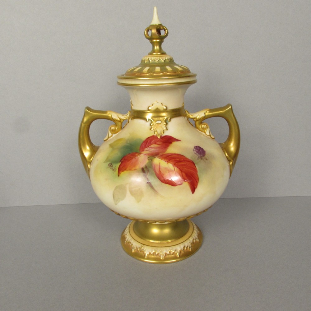 A twin-handled porcelain urn with a finial lid, featuring hand-painted autumn foliage and fruit decoration with rich gilding on the handles, neck, and base. View III