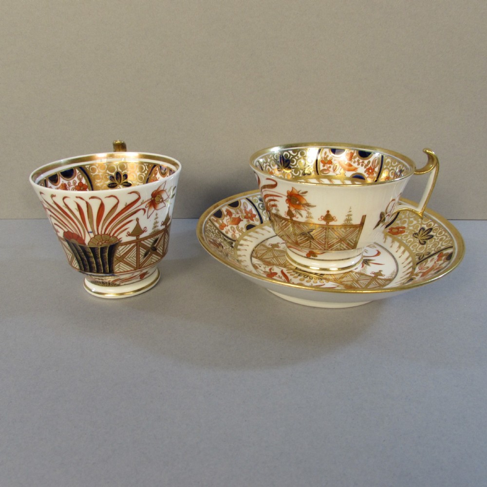 A Regency Spode porcelain trio consisting of a teacup, coffee cup, and matching saucer decorated with red, blue, and gold Imari style patterns.