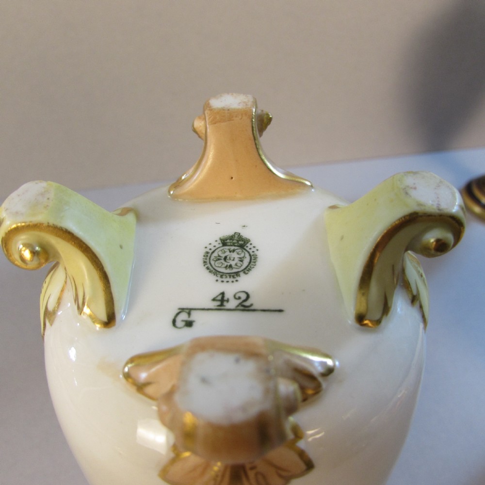 A cylindrical soft cream porcelain vase decorated with a painted scene of Highland sheep, featuring a reticulated gilt rim and four gilded scroll feet. View III