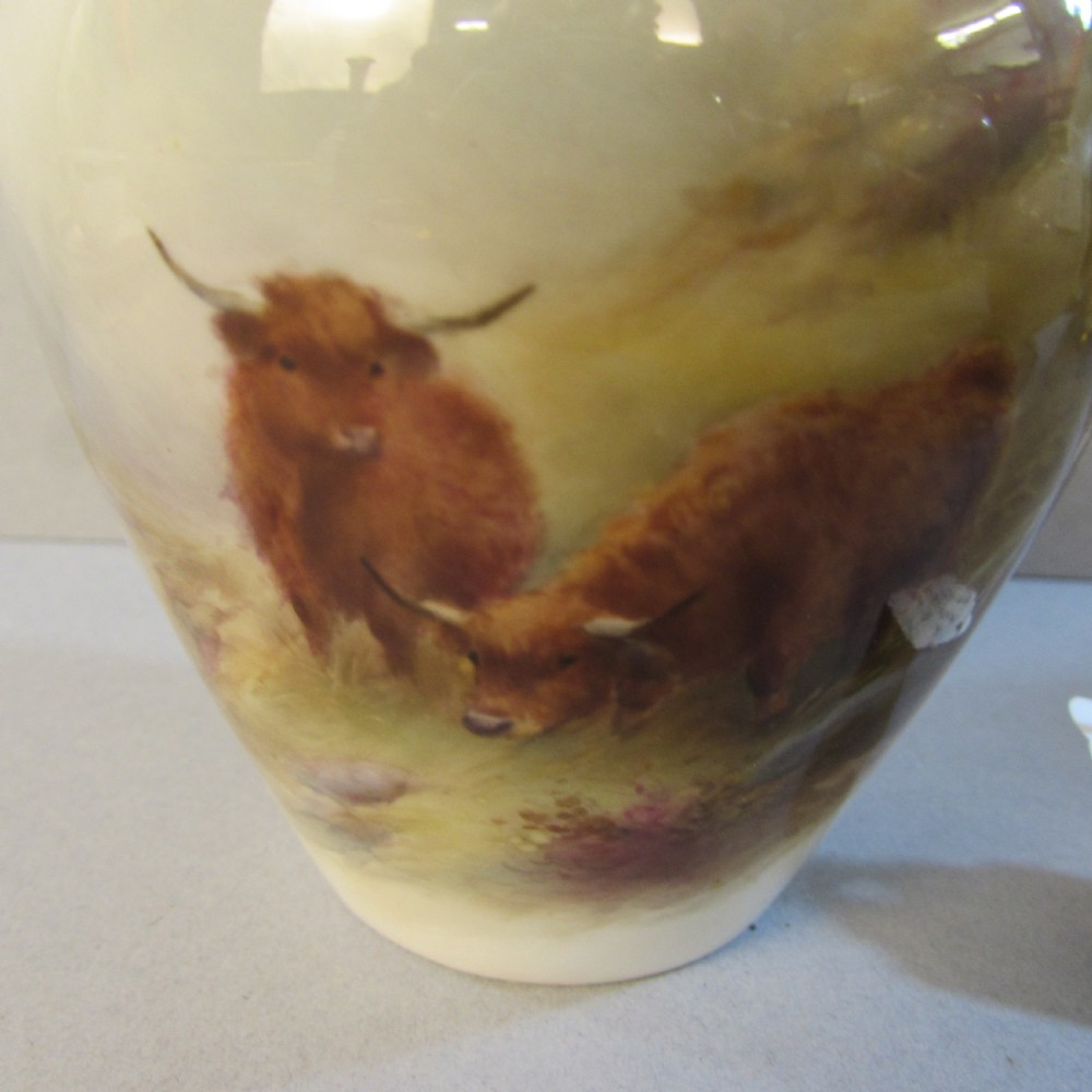 A cream porcelain vase with reticulated gilt rim, twin handles, and a hand-painted scene depicting Highland cattle in a misty landscape. View III