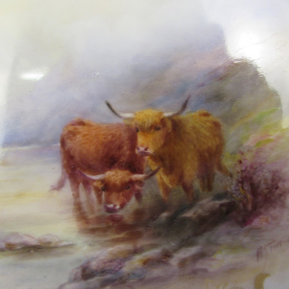 A pair of round antique Royal Worcester porcelain cabinet plates featuring hand-painted Highland cattle landscape scenes encircled by elaborate gilded cobalt blue borders. View IV