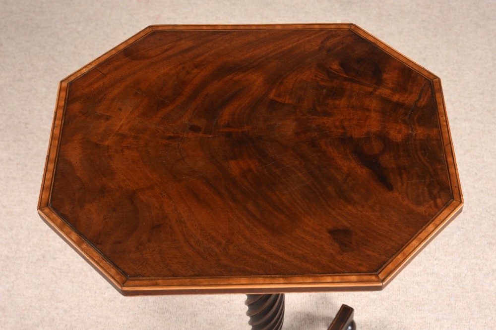 An antique mahogany tripod table featuring an octagonal top with crossbanded inlay, a spiral-twisted central pedestal, and splayed legs terminating in ball feet. View IV