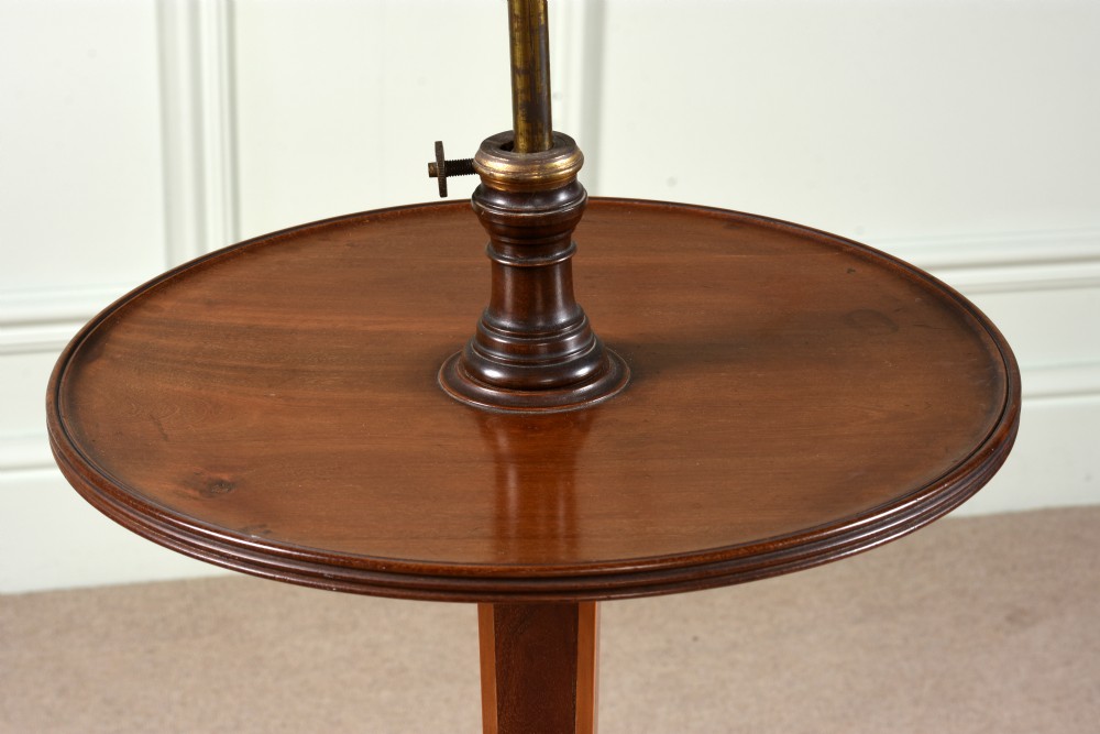 An Edwardian mahogany shaving stand featuring a shield-shaped adjustable mirror on a brass column above a round tray and tripod legs. View II