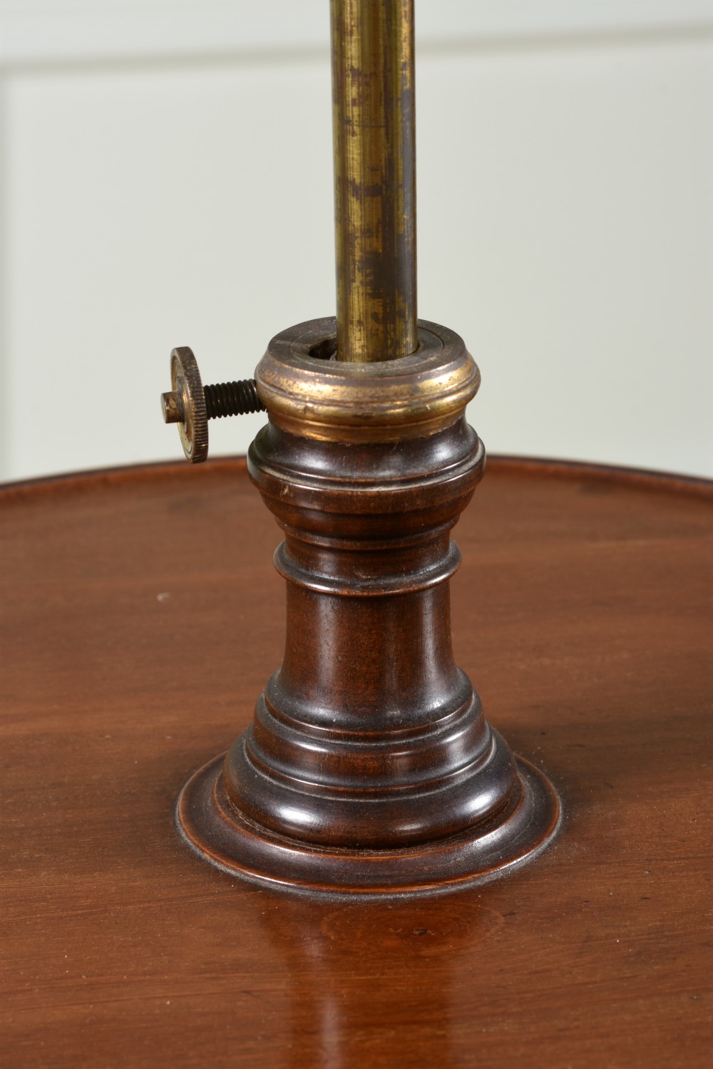 An Edwardian mahogany shaving stand featuring a shield-shaped adjustable mirror on a brass column above a round tray and tripod legs. View III