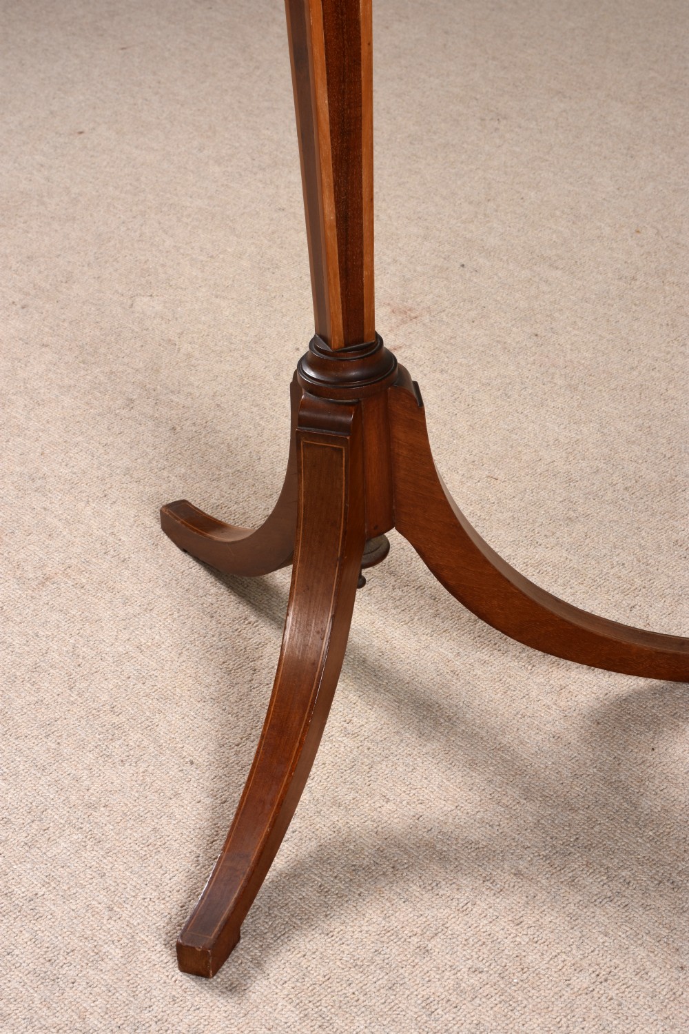 An Edwardian mahogany shaving stand featuring a shield-shaped adjustable mirror on a brass column above a round tray and tripod legs. View IV