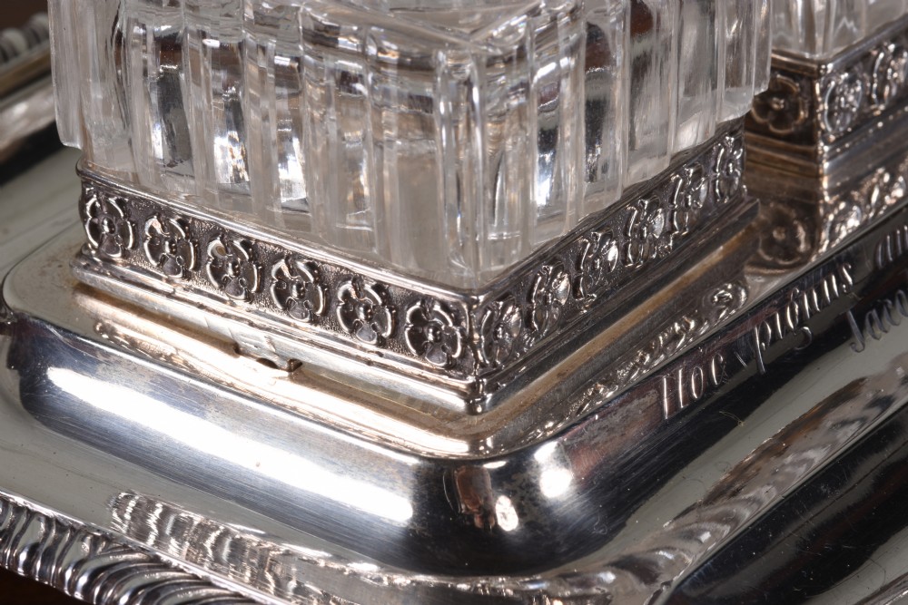 An Edwardian sterling silver desk stand with two cut-glass inkwells, a central chamber stick, and an engraved pen tray resting on paw feet. View V