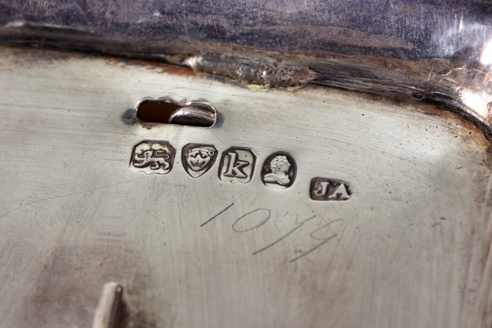 An Edwardian sterling silver desk stand with two cut-glass inkwells, a central chamber stick, and an engraved pen tray resting on paw feet. View VII