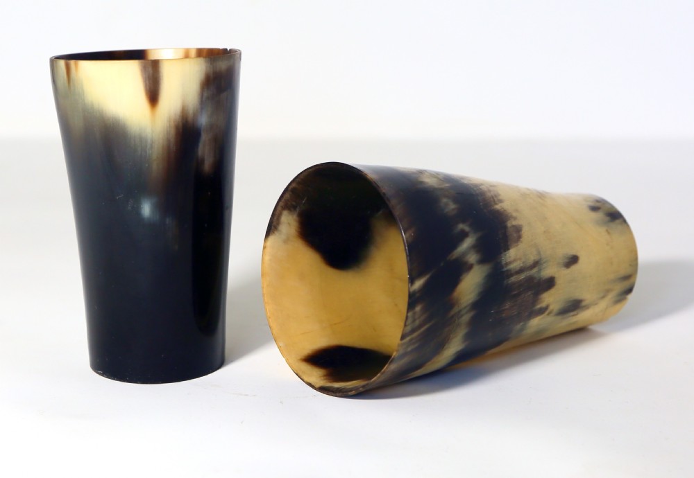 A pair of tapered Victorian drinking beakers crafted from natural horn featuring mottled dark brown and translucent honey tones.