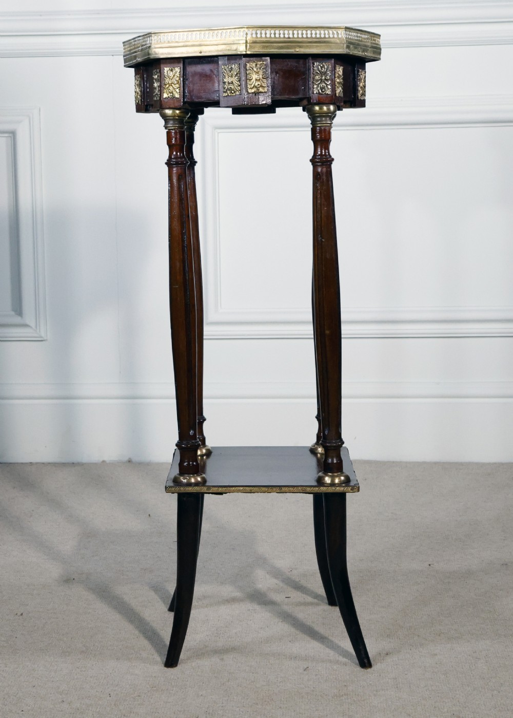 A tall French mahogany octagonal occasional table featuring an inset marble top with a pierced brass gallery rail, ormolu mounts, a lower shelf, and slender legs. View II